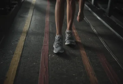 A close view of a treadmill running belt worn pale in a stripe down its centre.