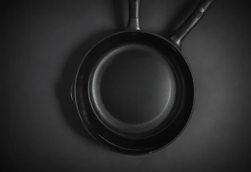 A plain steel frying pan photographed from directly overhead.