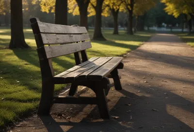 An empty wooden park bench seen from the side, centered in frame.