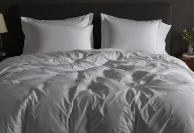 A neatly made bed with a plain duvet in a quiet bedroom.