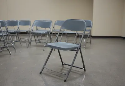 A bare metal folding chair in an empty break room.
