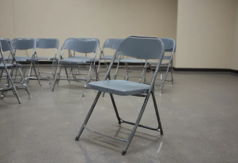 A bare metal folding chair in an empty break room.