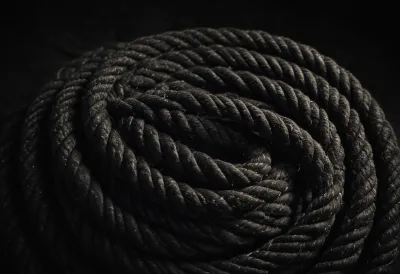 A thick ship's rope coiled on bare dark stone.