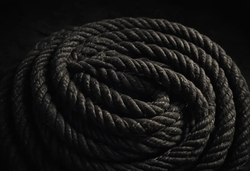 A thick ship's rope coiled on bare dark stone.