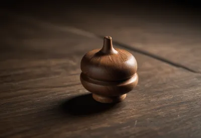A small wooden spinning top on a bare tabletop.